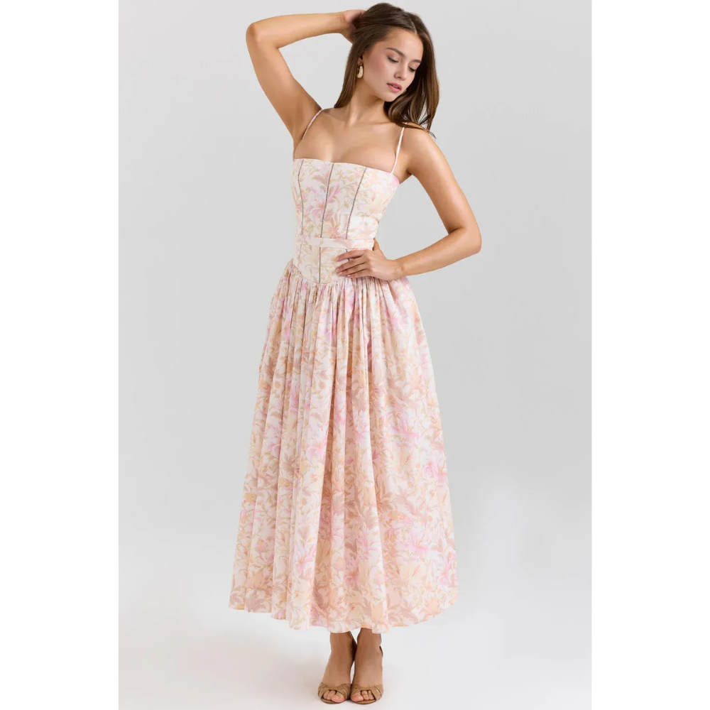 Women's floral maxi dress in pastel pink with straps, fitted bodice, and flowing skirt