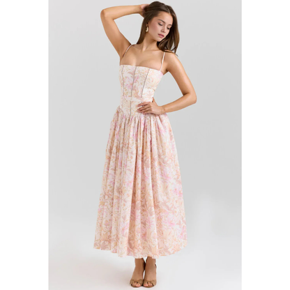 Women's floral maxi dress in pastel pink with straps, fitted bodice, and flowing skirt