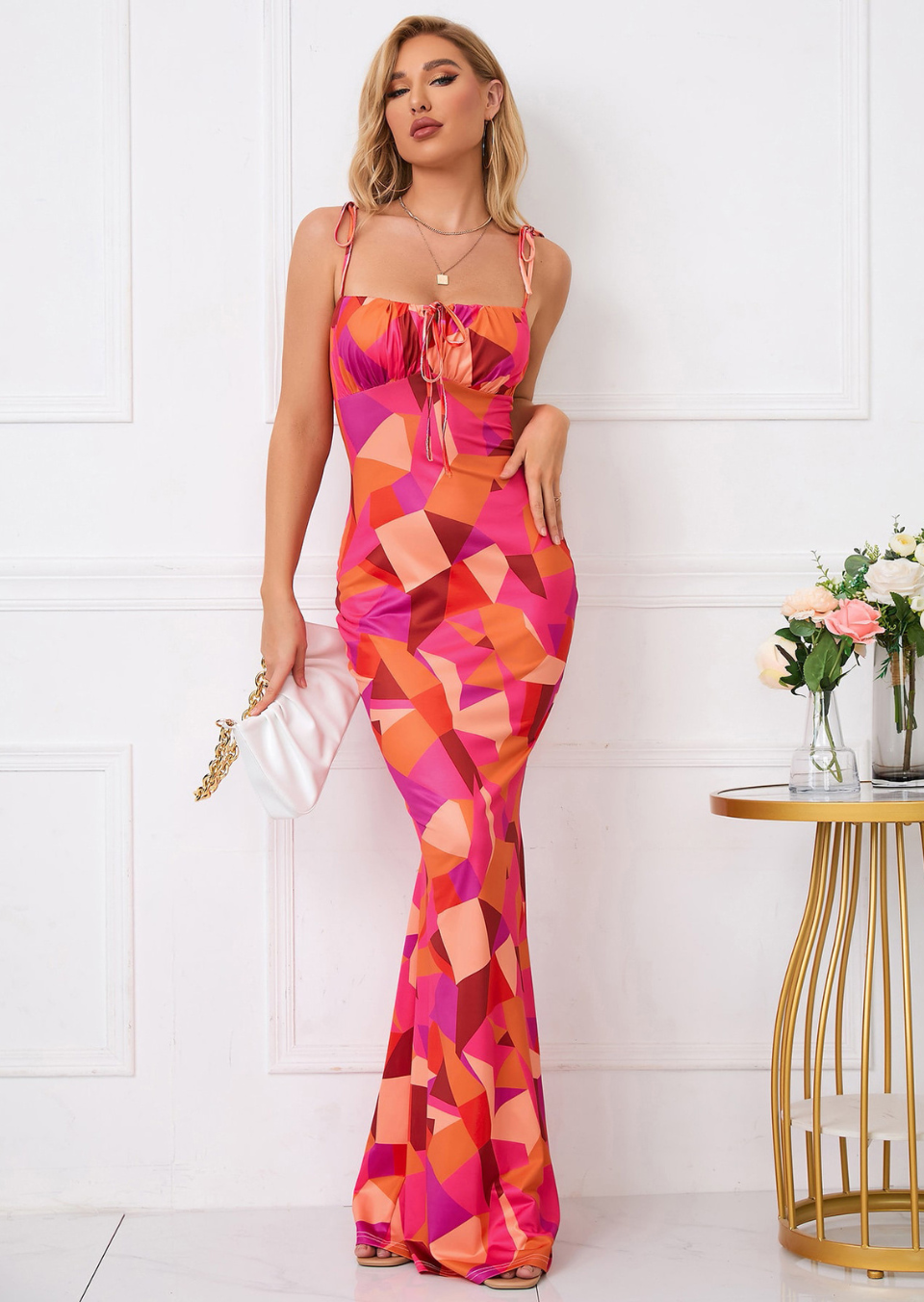 Front view of colorful geometric maxi dress with square neckline, tie straps, and fit