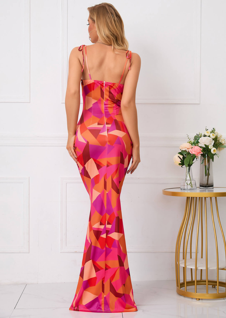 Back view of a pink and orange floral maxi dress with tie straps and fitted silhouette