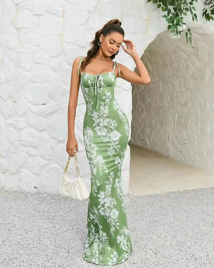 Side view of green floral maxi dress with square neckline, tie straps, and sleek bodycon fit