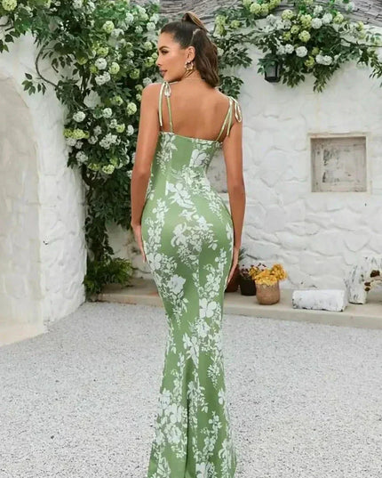 Back view of green floral maxi dress with open back, tie shoulder straps, and long fitted skirt