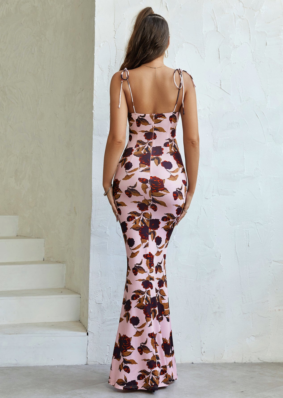Back view of pink floral maxi dress showing open back, tie straps, and floor-length fit