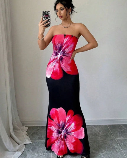 Woman in pink floral strapless maxi dress with black base and bold oversized blossom print