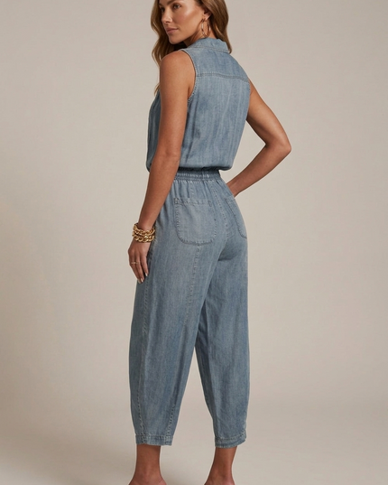 Back view of light blue sleeveless denim romper with pockets and elastic waist