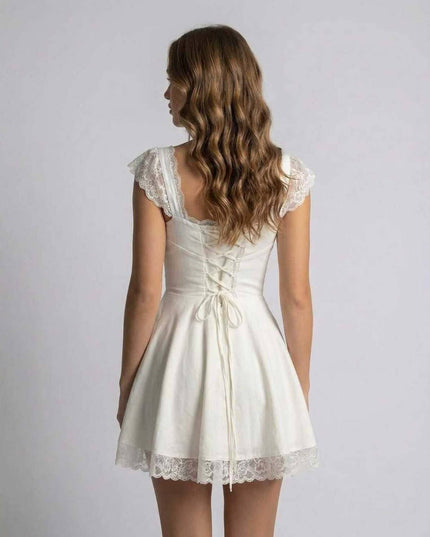 Back view of white lace mini dress with lace-up detail and scalloped sleeve trim
