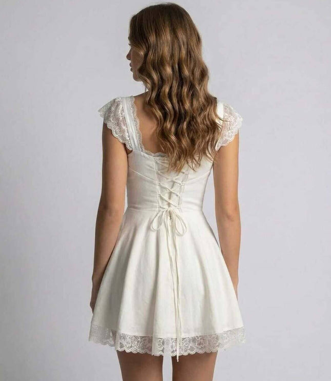 Back view of white lace mini dress with lace-up detail and scalloped sleeve trim