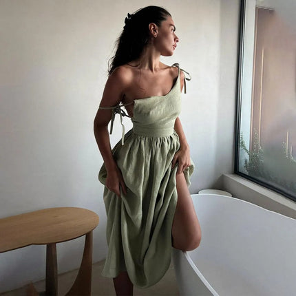 Side view of sage green summer linen dress with one-shoulder tie detail and gathered skirt