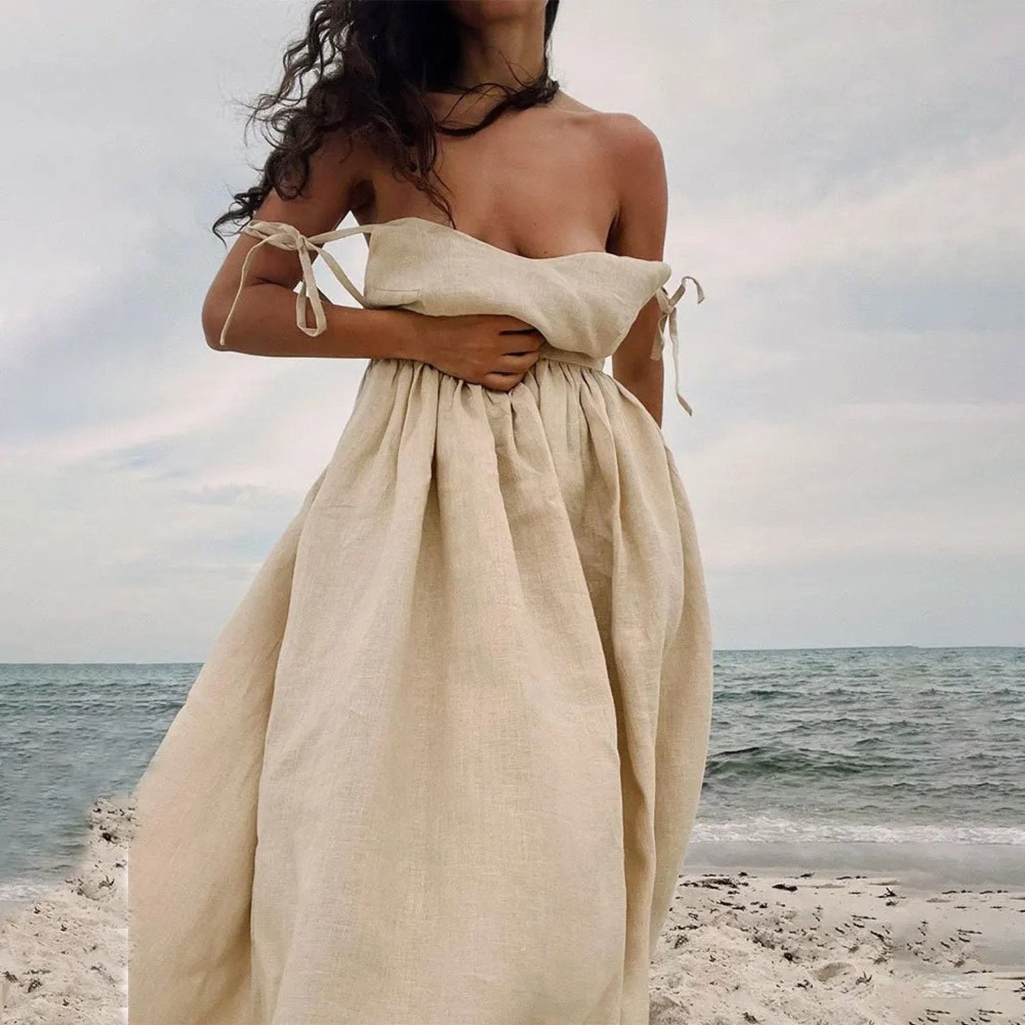 Beige strapless linen maxi dress with tied side straps and loose flowing summer skirt
