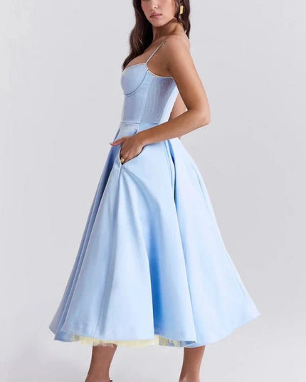 Light blue midi dress with spaghetti straps, fitted bodice, and full wedding guest skirt