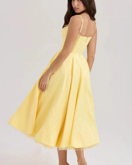 Back view of yellow midi dress showing fitted waist, open back, and voluminous skirt