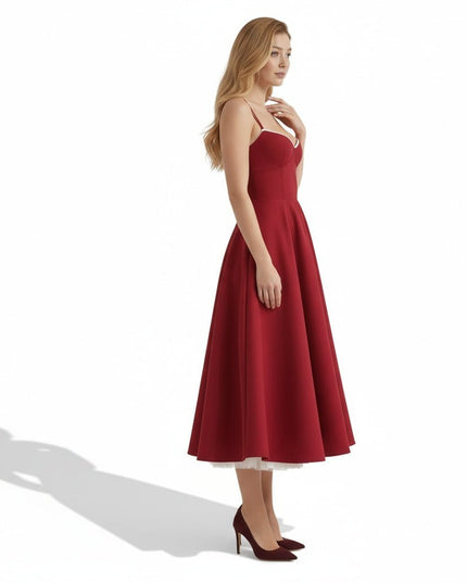 Side view of a burgundy wedding guest midi dress with flared skirt and shoulder straps