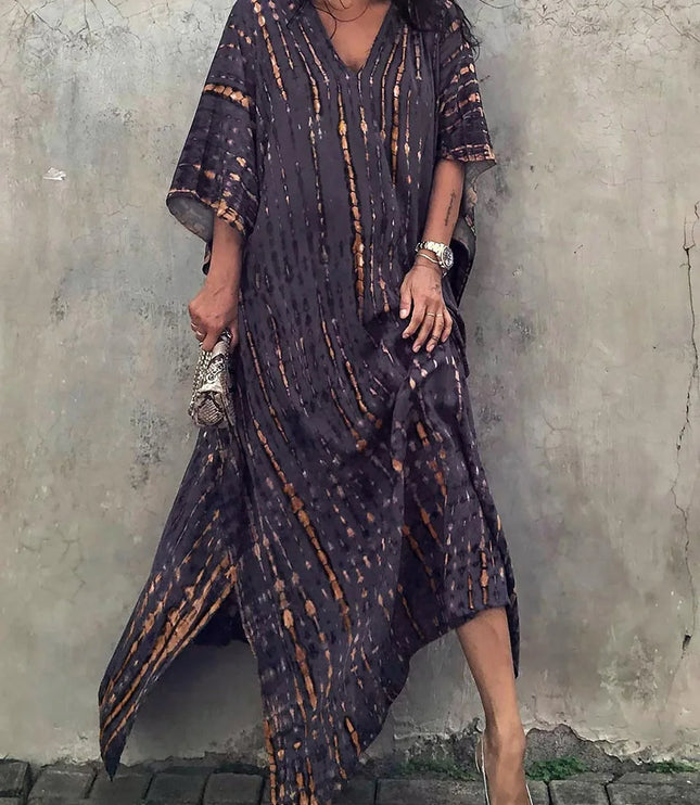 Dark charcoal tie dye maxi dress with orange accents, V-neck, and asymmetrical hem