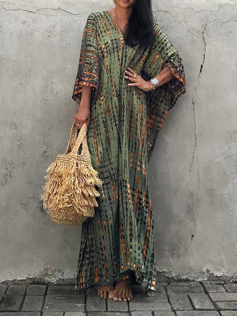 Olive green tie dye maxi dress with orange accents, wide sleeves, and a flowing bohemian summer dress fit