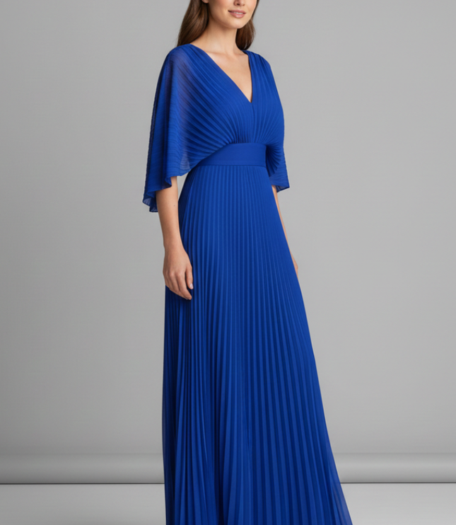 Side view of royal blue pleated maxi dress with V neck and draped cape sleeves