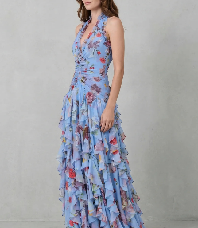 Side view of blue floral halter maxi dress with layered ruffles and floor-length hem