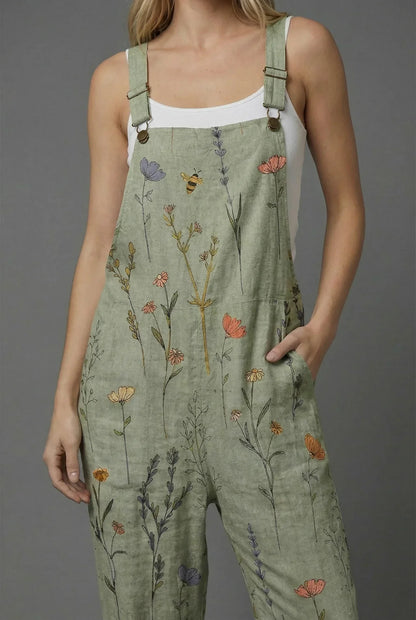 Close-up of sage green wide leg romper with floral print, adjustable straps, and front pocket
