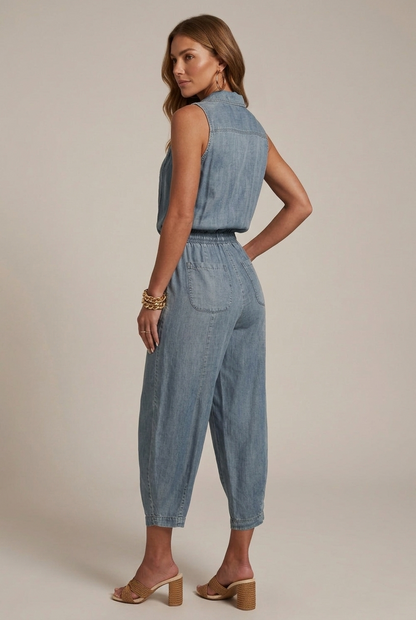 Back view of light blue sleeveless denim romper with pockets and elastic waist