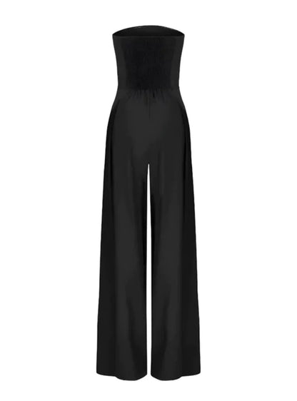 Black strapless wide leg jumpsuit with pocket detail styled on a model against draped backdrop