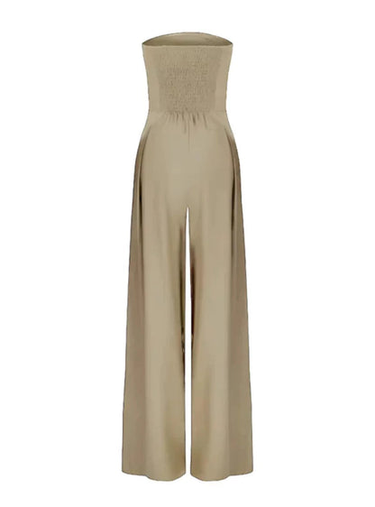 Beige strapless jumpsuit shown flat with smocked back and flowing wide leg pants