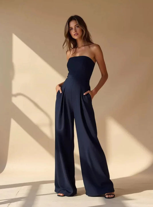 Navy strapless wide leg jumpsuit with fitted waist and side pockets on a model