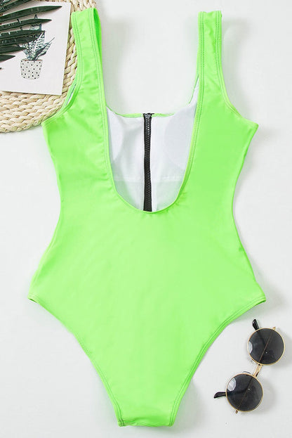 Neon green one piece bathing suit laid flat with black zipper and wide shoulder straps