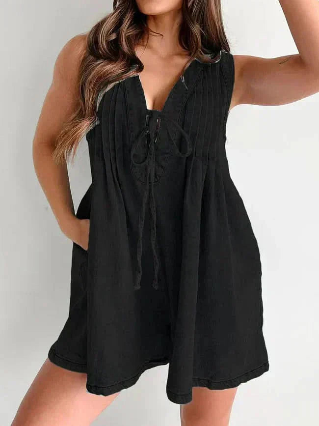 Black women's denim romper with sleeveless V-neck, tie front, and loose mini short silhouette
