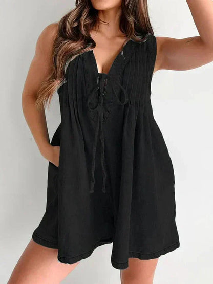 Black women's denim romper with sleeveless V-neck, tie front, and loose mini short silhouette