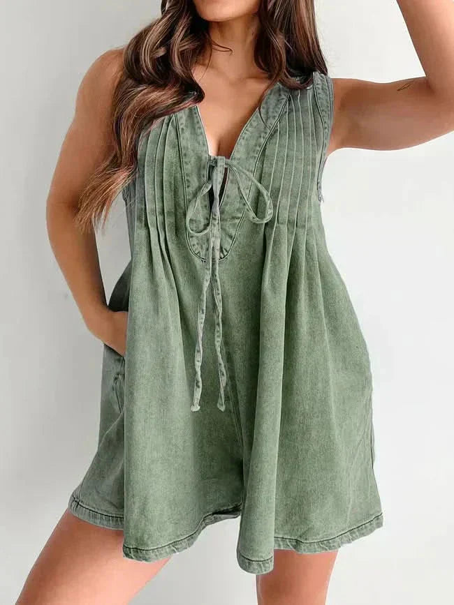 Olive green women's mini denim romper with V-neck tie front, pleated top, and relaxed shorts fit