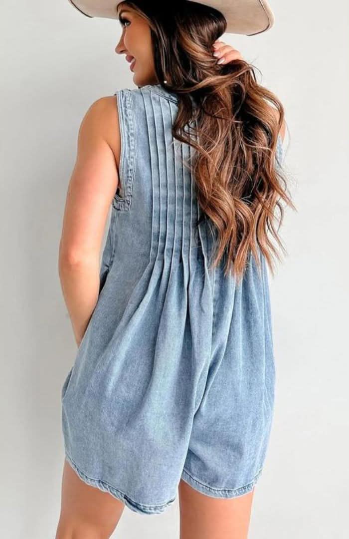 Back view of light blue mini denim romper with pleated yoke, sleeveless design, and loose fit
