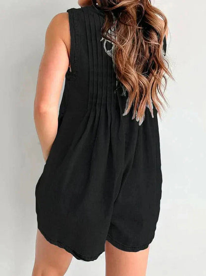 Back view of black casual denim romper with pleated back detail and relaxed sleeveless cut