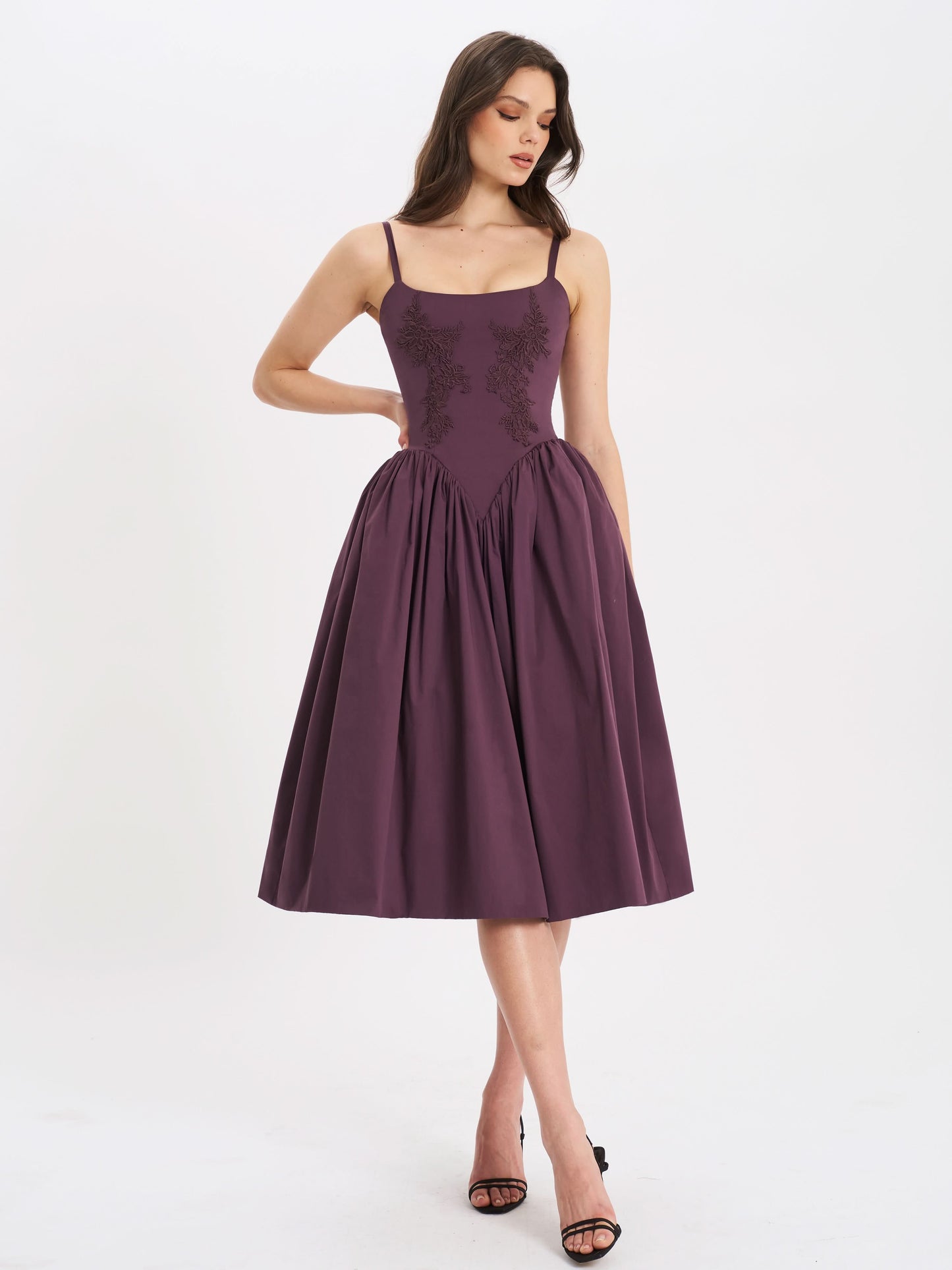 Side angle of purple midi dress showing fitted embroidered bodice and flared skirt
