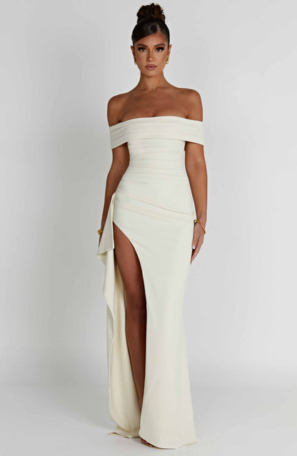 Front view of cream off shoulder formal maxi dress with fitted waist and slit