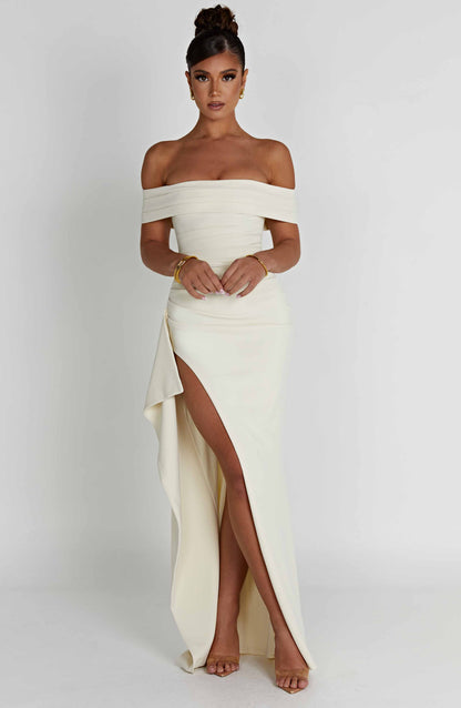 Cream off shoulder maxi dress with high slit and flowing skirt, angled front view