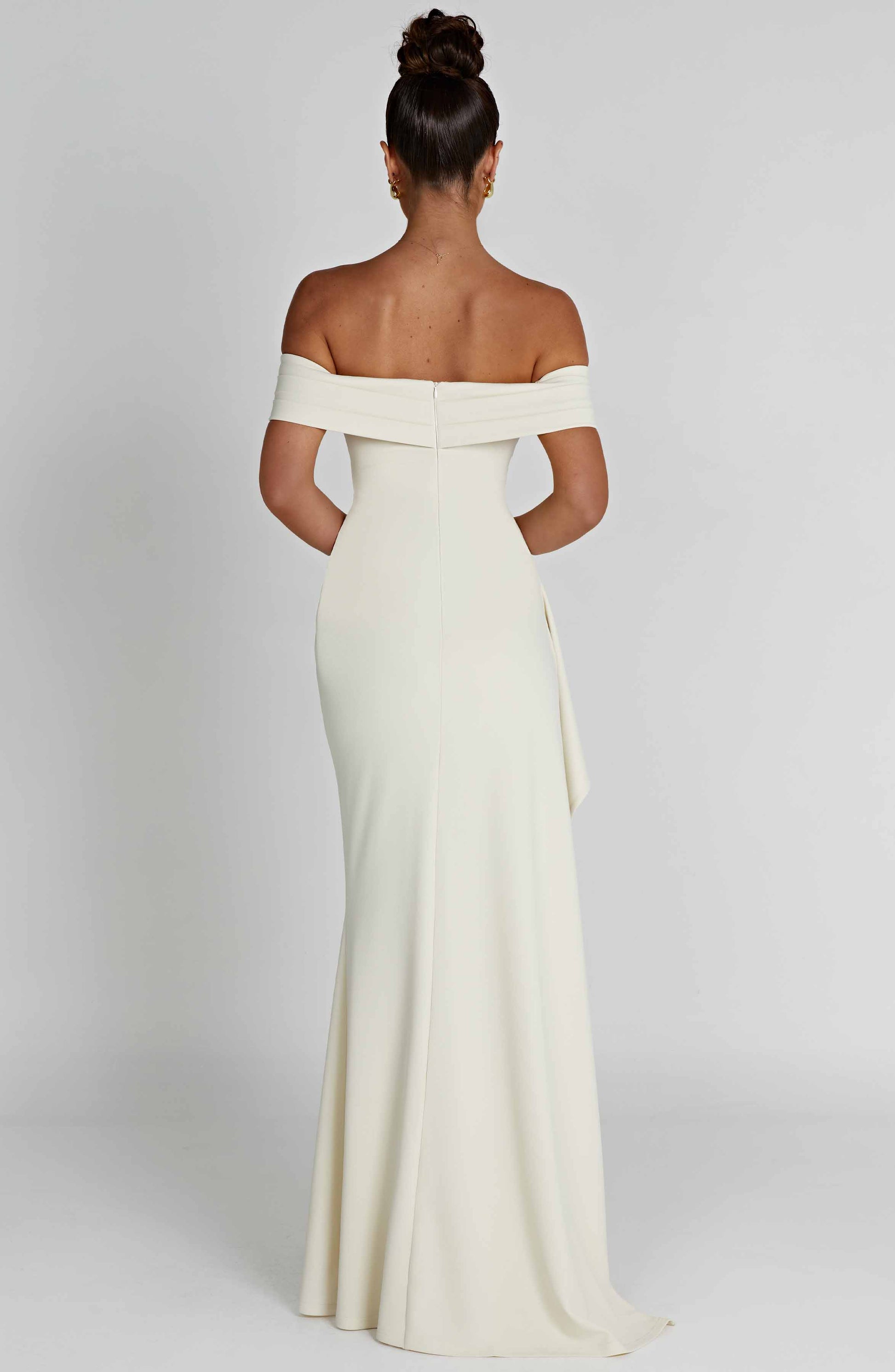 Back view of ivory off shoulder maxi dress with fitted bodice and floor length skirt