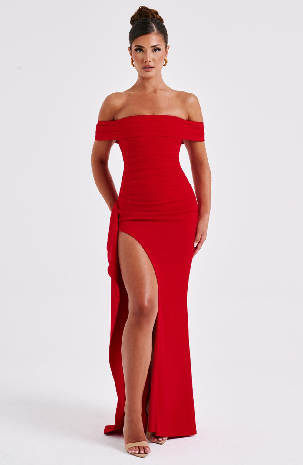 Angled front view of red off shoulder maxi dress with fitted waist and flowing skirt