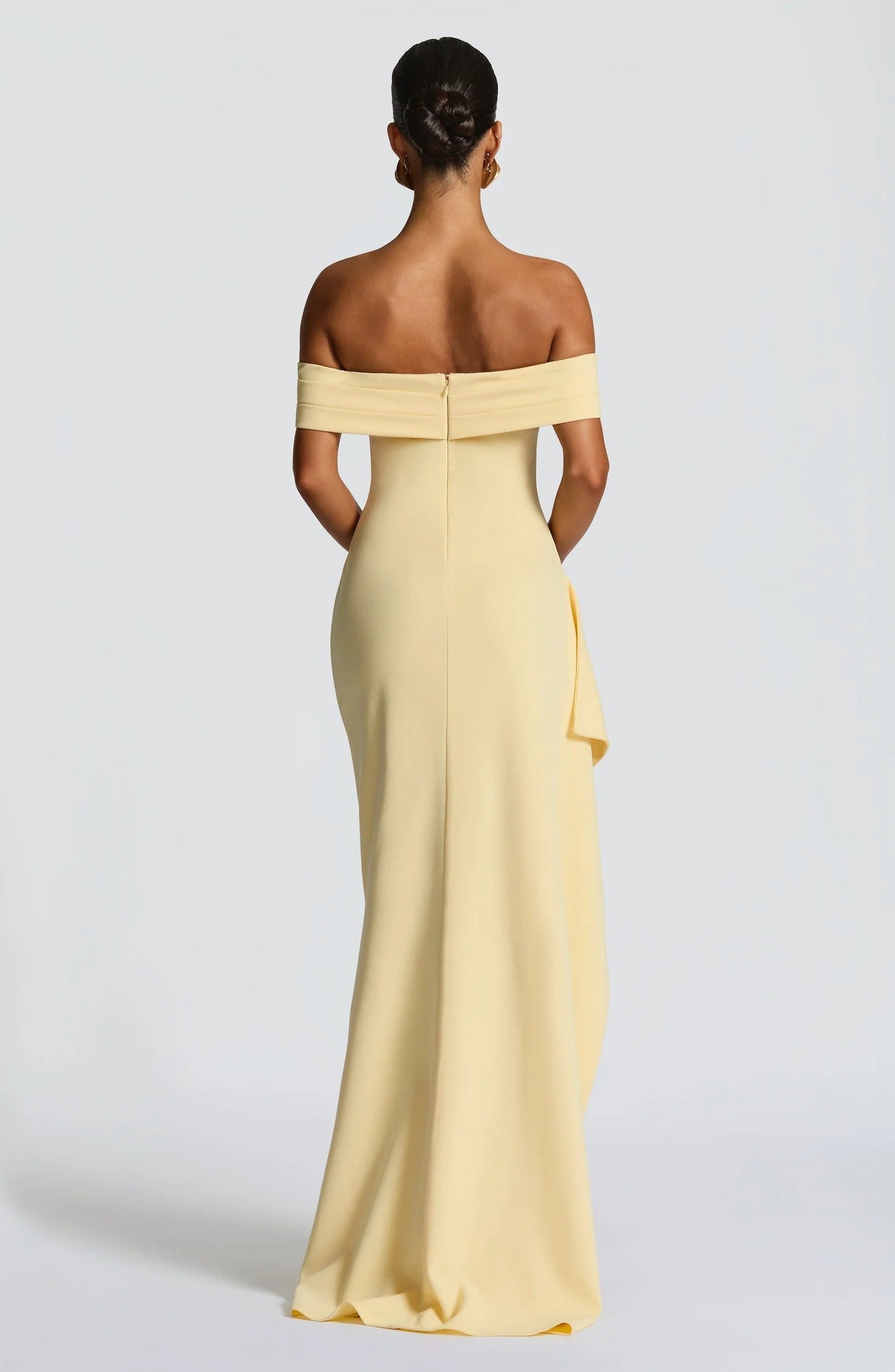 Back view of pale yellow off shoulder maxi dress with zip closure and smooth floor length skirt