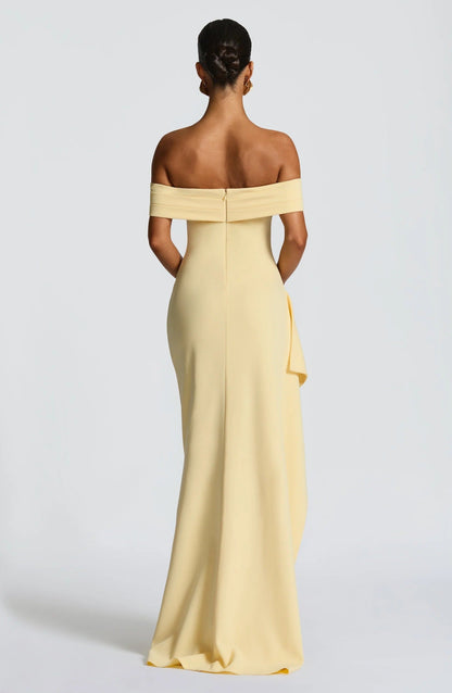 Back view of pale yellow off shoulder maxi dress with zip closure and smooth floor length skirt
