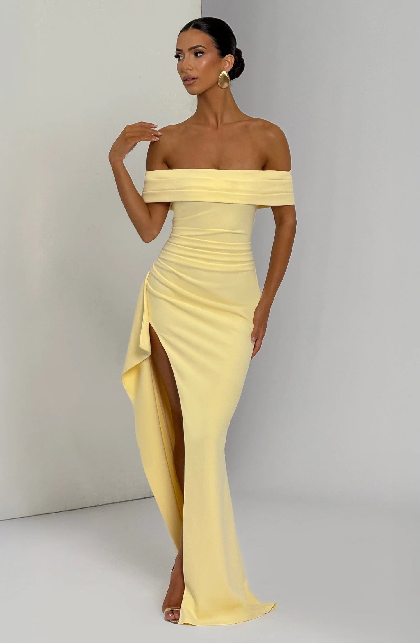 Front view of pale yellow off shoulder maxi dress with flowing chiffon panels and formal gown style