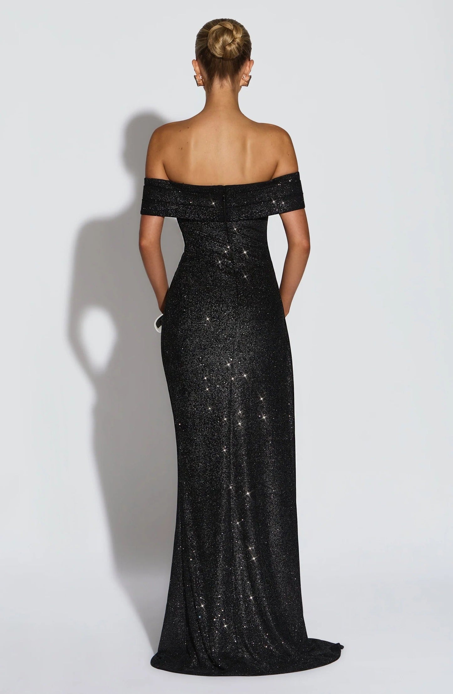 Back view of black off shoulder maxi dress with glitter finish and fitted silhouette