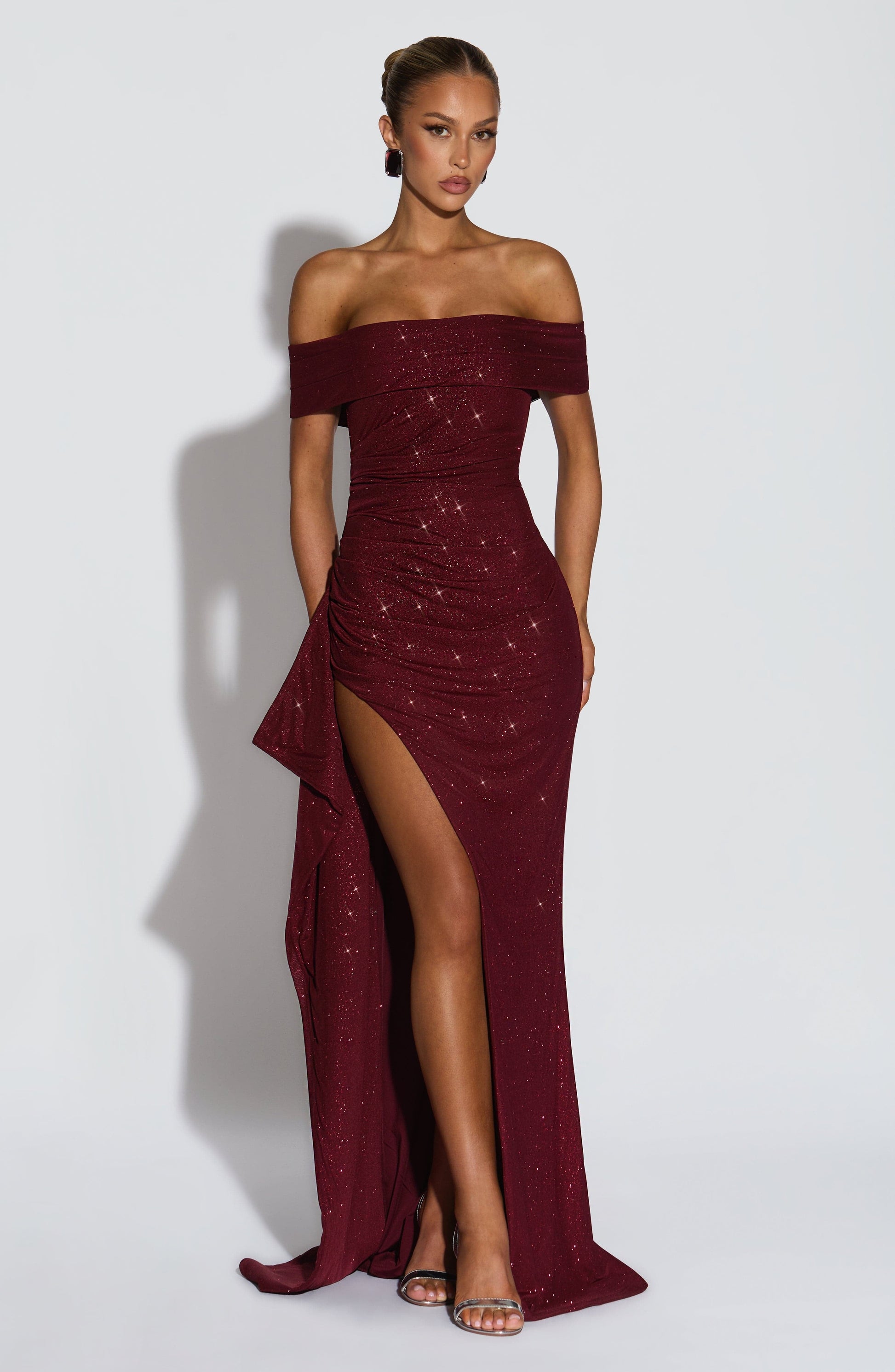 Front view of burgundy off shoulder maxi dress with glitter detail and high slit