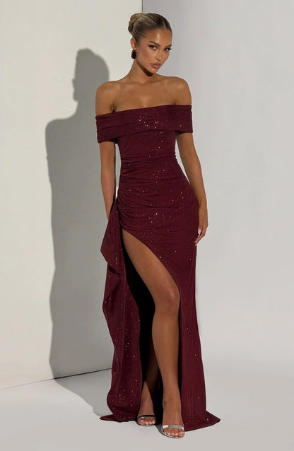 Front view of burgundy formal off shoulder maxi dress with high slit and glittery finish