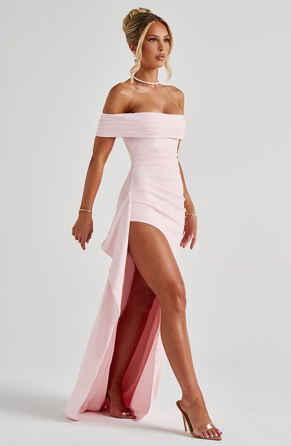 Side view of light pink maxi dress with off shoulder top, ruched detail, and flowing panel