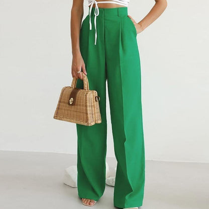 Green high waisted wide leg linen pants styled with a white crop top and woven handbag