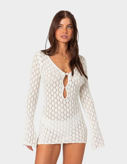 White crochet mini dress with tie front detail, long sleeves, and sheer lace texture