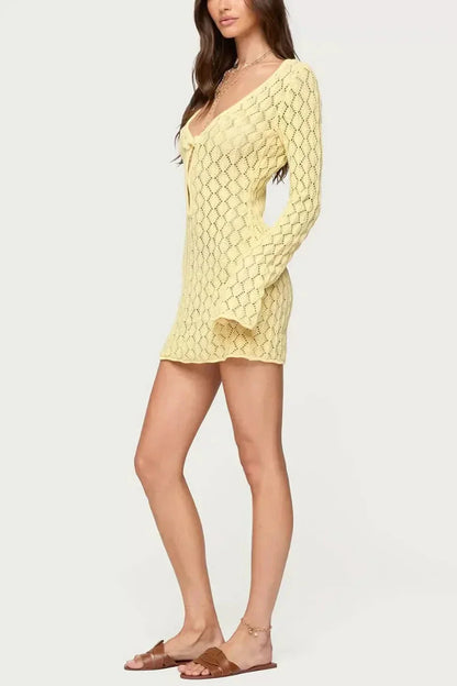 Side view of yellow crochet tie front mini dress with long sleeves and short hem
