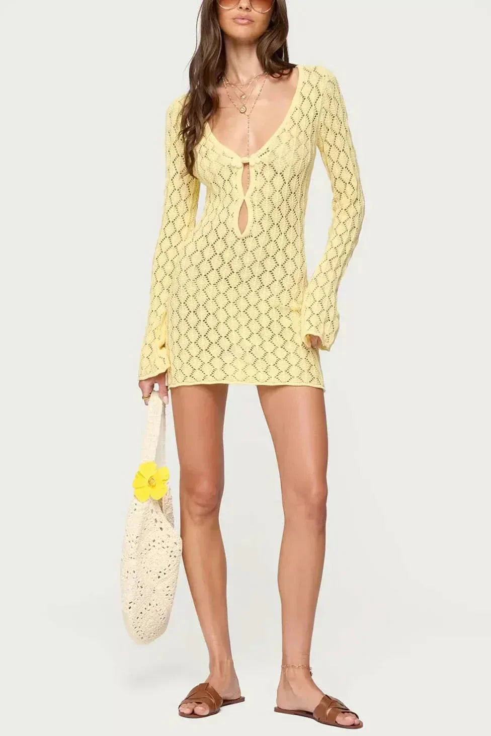 White crochet tie front mini dress with deep V neckline, long sleeves, and short hem