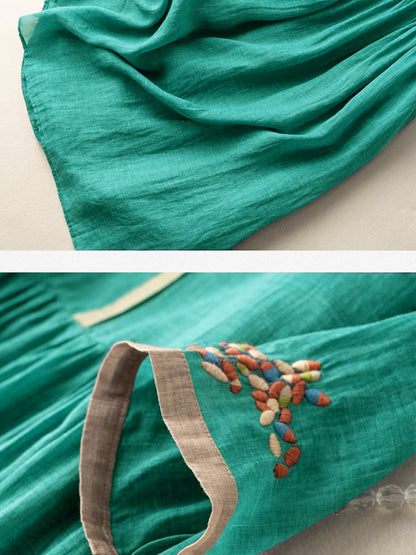 Close-up of teal summer dress showing embroidered sleeve cuff and lightweight fabric texture