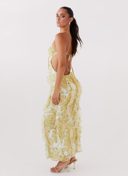 Side view of floral maxi dress with open back, thin straps, and flowing ruffle details