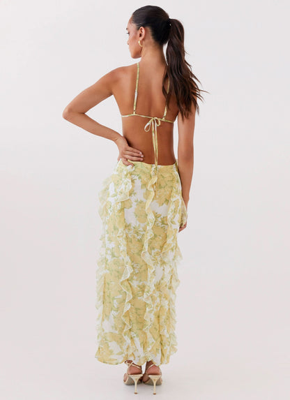 Back view of women's floral maxi dress with low open back, tie straps, and layered ruffles